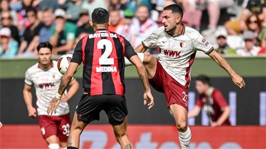 Leverkusens Facundo Medina (links) und Arijon Ibrahimovic vom FC Augsburg kämpfen um den Ball.