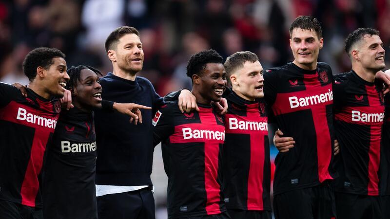 Bayer feiert Alonso und gefühlt schon den Titel Leverkusens Trainer Xabi Alonso (3.v.l.) feiert nach der Partie mit den Spielern vor der Kurve.