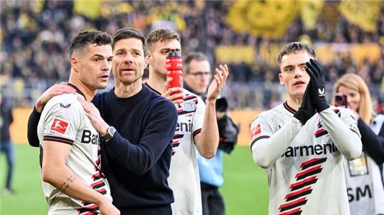 Leverkusens Trainer Xabi Alonso feiert mit seinen Spielern das Remis bei Borussia Dortmund.