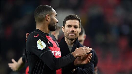 Leverkusens Trainer Xabi Alonso (r) feiert den Sieg mit Jonathan Tah.