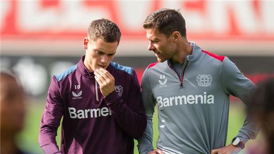 Leverkusens Trainer Xabi Alonso (r) im Gespräch mit Florian Wirtz.