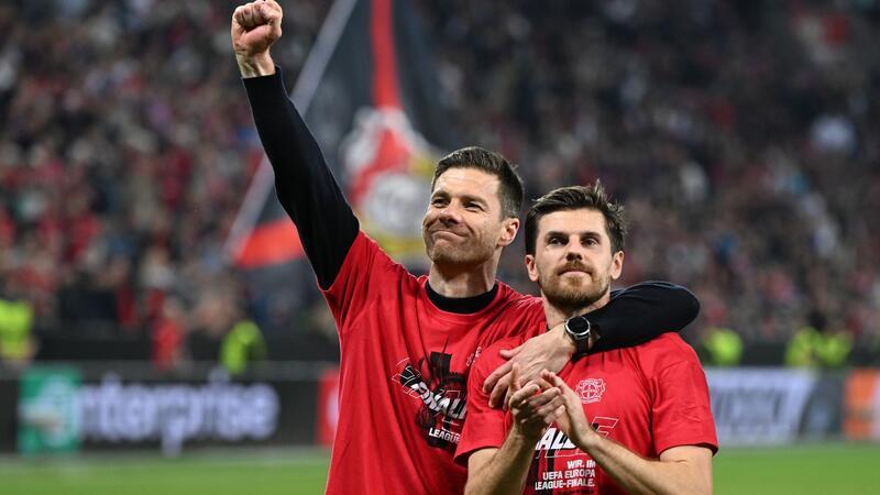 Triple greifbar: Alonso nach Last-Minute-Wahnsinn emotional Leverkusens Trainer Xabi Alonso und Jonas Hofmann (r) feiern mit den Fans nach dem Spiel gegen Rom.