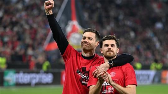 Leverkusens Trainer Xabi Alonso und Jonas Hofmann (r) feiern mit den Fans nach dem Spiel gegen Rom.