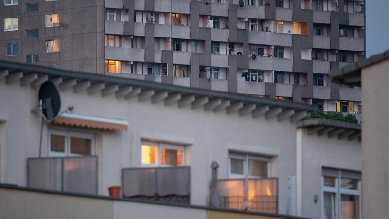 Licht brennt in den Fenstern von Wohnungen in Hochhäusern und Reihenhäusern.