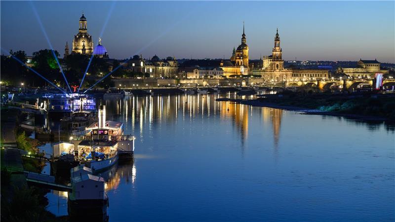 Bilder des Tages Lichter einer Party auf einem Schiff der Sächsischen Dampfschifffahrt Weiße Flotte sind am Abend vor der historischen Altstadtkulisse in Dresden an der Elbe mit der Frauenkirche (l-r), der Kuppel der Kunstakademie mit dem Engel „Fama“, dem Terrassenufer, dem Ständehaus, dem Hausmannsturm, der Hofkirche und der Semperoper zu sehen.
