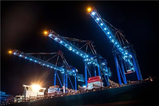 Lichter leuchten bei Nacht am Hafen.