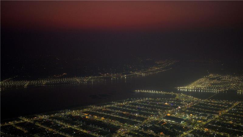 Lichter leuchten in provisorischen Zelten, in denen Pilger am Sangam, dem Zusammenfluss von Ganges und Yamuna und dem mythischen Fluss Saraswati, am Mauni Amavasya oder Neumondtag während des jährlichen einmonatigen religiösen Hindu-Festes Magh Mela in Prayagraj in Indien untergebracht sind.