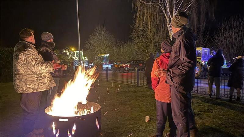 Letzte Lichterfahrt der Funken Crew: Ein Treckerfahrer berichtet Lichterfahrt als Event: Einige Zuschauer warteten mit Glühwein an der Feuertonne in Wenzendorf auf die bunt leuchtenden Fahrzeuge.