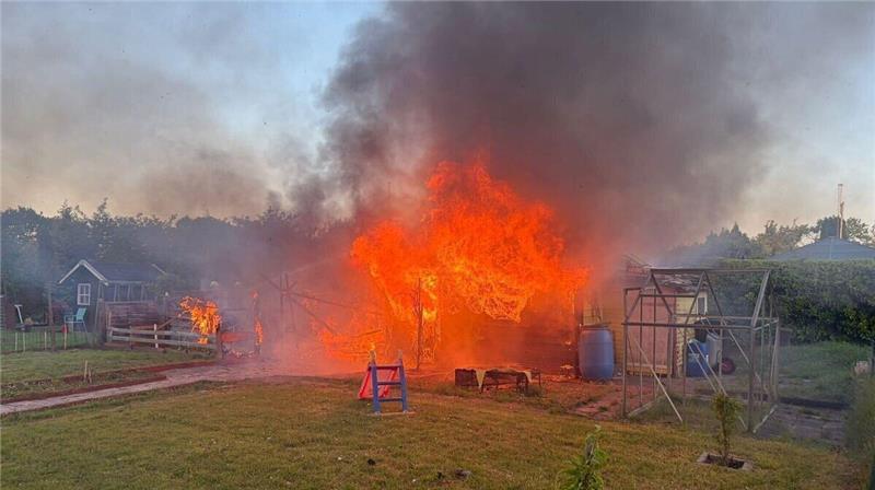 Lichterloh schlagen die Flammen aus dem Häuschen, als die Feuerwehr in der Anlage eintrifft.