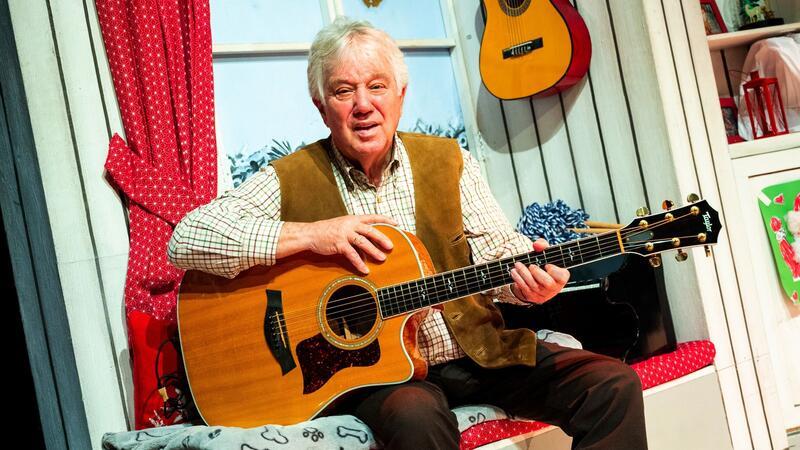 Liedermacher Rolf Zuckowski sitzt bei einem Fototermin mit seiner Gitarre im Schmidts Tivoli.