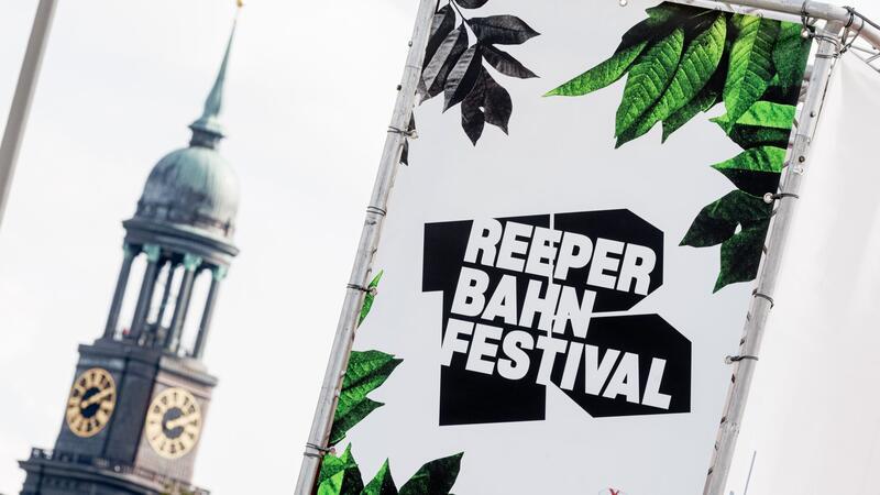 Logo und Schriftzug des Reeperbahnfestivals sind auf einem Transparent vor der Hauptkirche St.Michaelis zu sehen.