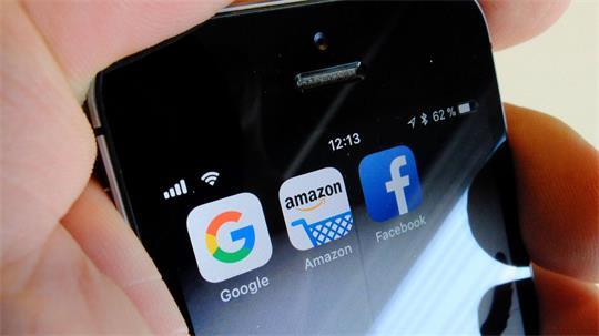 Logos für Apps der US-Internetkonzerne Google (l-r), Amazon und Facebook sind auf dem Display eines Smartphones zu sehen.
