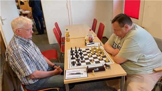 Ralf Schöngart von den Schachfreunden Buxtehude sitzt vor dem Schachbrett und seinem Gegner.