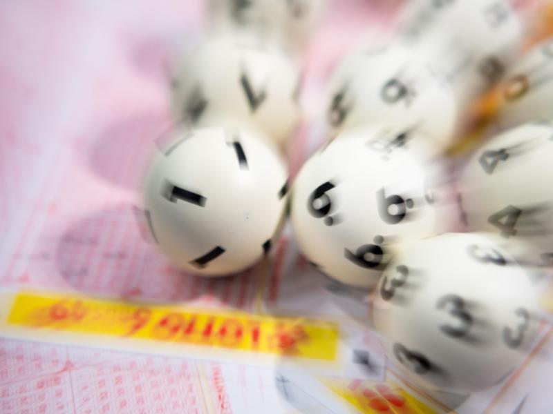 Lotto-Kugeln liegen auf einem Lottoschein. Foto: Tom Weller/dpa/Symbolbild