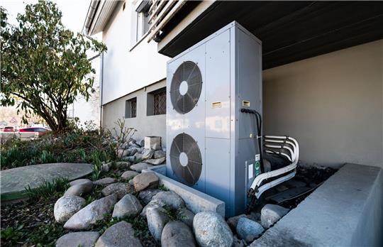Lüftungsanlage einer Wärmepumpe vor einem Mehrfamilienhaus. Foto: dpa