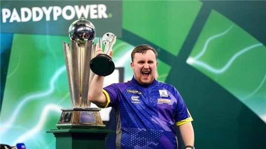 Luke Littler jubelt mit dem Pokal für den zweiten Platz.