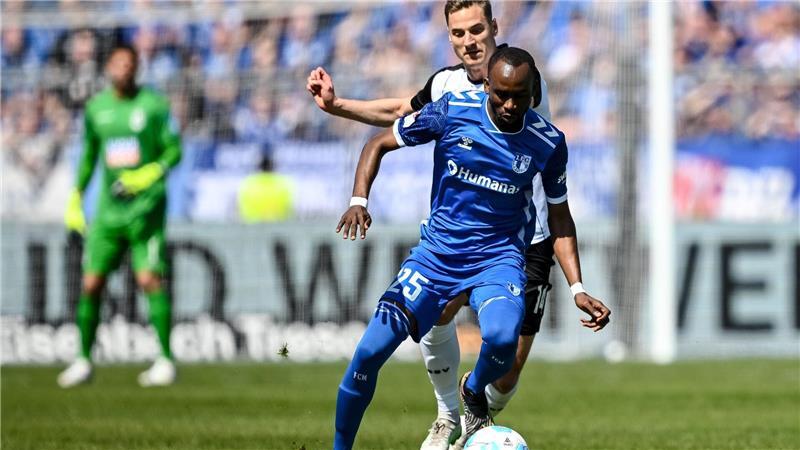 Magdeburgs Silas Gnaka (l) verteidigt den Ball gegen Ulms Dennis Dressel.