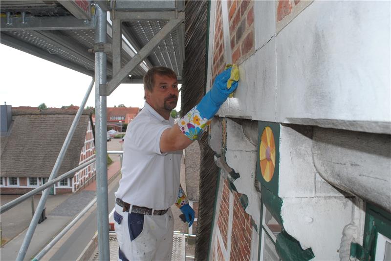 Maler Oliver Minow vom Malerbetrieb Ralf Behrens aus Stade arbeitet in Westerjork in luftiger Höhe an der Sanierung der Fachwerk-Fassade des Museum Altes Land in Jork.   Foto Vasel