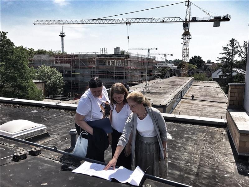 Mandy Nagel, Anna Ellerbrock (beide Stade) und Schulleiterin Bettina Fees-McCue (von links) informieren sich über den Baufortschritt an der Halepaghen-Schule. Foto: Wisser