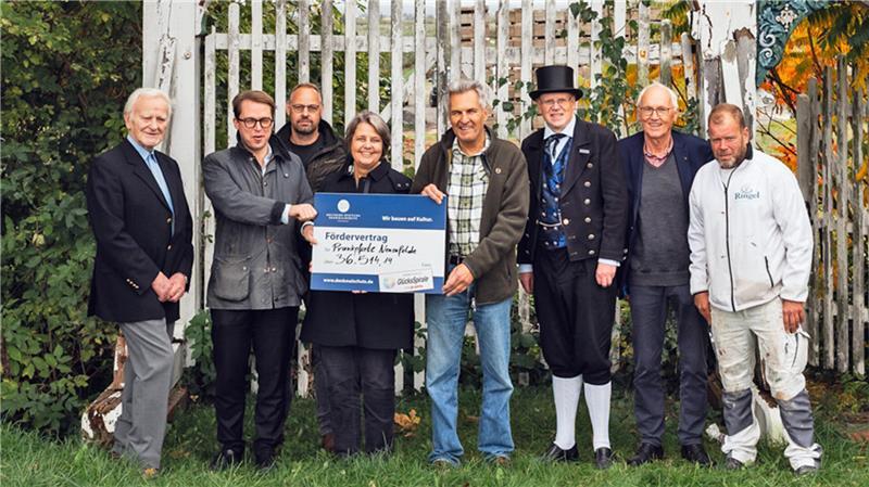 Glücksspieler retten morsche Altländer Prunkpforte in Neuenfelde Manfred Hoffmann (Bürgervertretung), Robert Eberhardt (DSD), Jendrik Cohrs (Zimmerei Cohrs), Madeleine Göhring (Lotto Hamburg), Uwe Heck (Denkmal-Eigentümer), Dr. Boy Friedrich (Bürgervertretung), Norbert Dierks (Bürgervertretung) Björn Mielke (Maler Ringel) zeigen den Fördervertrag (von links).