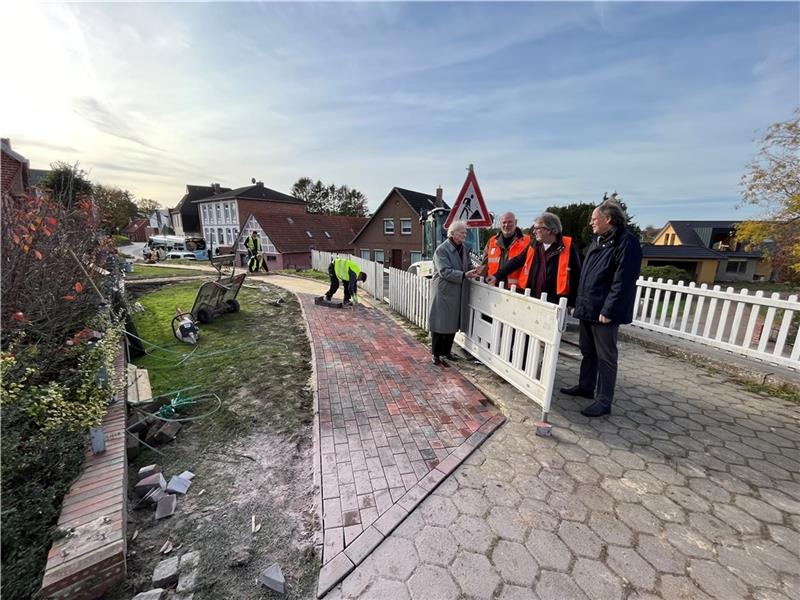 Manfred Hoffmann und Dr. Boy Friedrich von der Bürgervertretung Neuenfelde-Francop-Cranz nehmen Henning Rathjens und Klaus-Peter Thießen von der Hamburg Port Autority (HPA) in ihre Mitte (von links) und begutachten den neuen historisierende