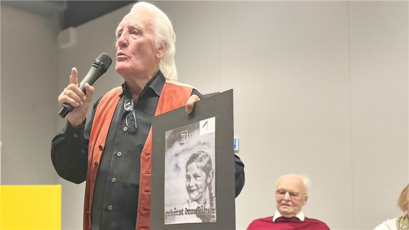Als Kinder im Bombenhagel: Zeitzeugen berichten von grausamen Erlebnissen Manfred Hüllen erklärt den Schülern ein nationalsozialistisches Propagandaplakat.