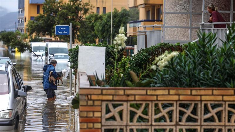 Mann mit Hund im Hochwasser: Starkregen überflutet Valencia
