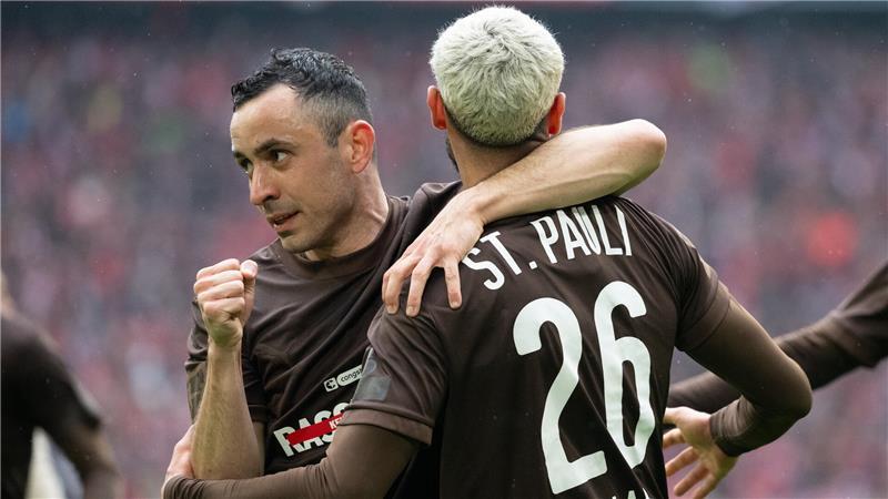 Pauli macht Bayern das Leben schwer - Ex-BSV-Spieler trifft Manolis Saliakas vom FC St. Pauli (l) umarmt seinen Teamkollegen Elias Saad (r) nach dem 1:1 Treffer.