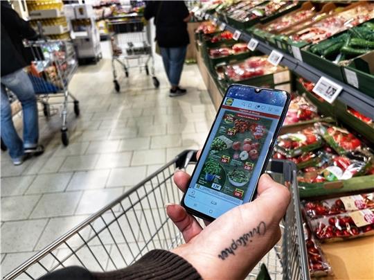 Manuela guckt beim Einkauf im Discounter genau auf Preise und Sonderangebote. Gemüse ist teuer geworden. Nur eine Gurke wird in ihrem Wagen landen. Foto: Richter