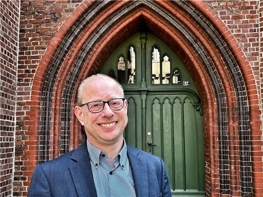 Marc Wischnowsky vor dem Tor von St. Wilhadi, der Kirche, die seinem neuen Büro in der Ritterstraße in Stade am nächsten liegt. Foto: Richter