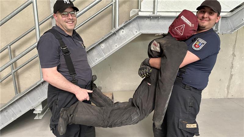 Feuer im CFK Nord: So plant Stades Ortsbrandmeister das Horrorszenario Marcel Engel (links) und Tjark Brütt vom Zug II der Stader Feuerwehr platzieren einen Dummy für die Feuerwehrübung. Die Puppe wiegt knapp 80 Kilo.