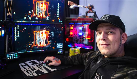 Marcel Eris, YouTuber, sitzt in seinem Arbeitszimmer am Tisch vor Computermonitoren. Foto: Philipp Schulze/dpa