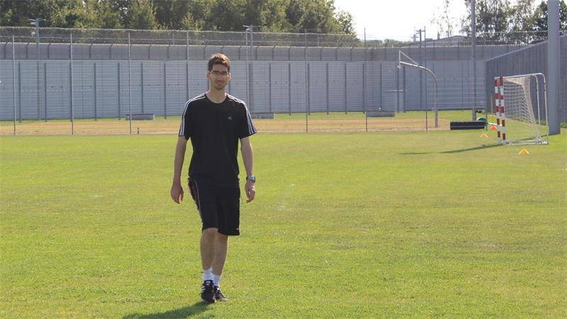 Sportpädagoge Marco Hendreich steht auf dem Rasenplatz der JVA Bremervörde.