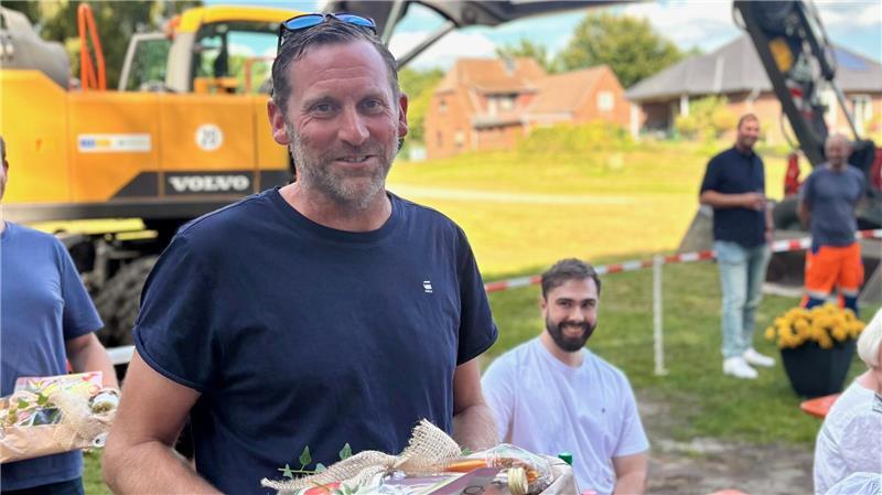 Abschiedsfest für die Bauarbeiter: Ab Freitag ist die Aue-Brücke frei Marcus Müller bekommt von den Bargstedtern ein Geschenk als Anerkennung. Er war immer bereit zu helfen, wenn es durch die Vollsperrung Probleme gab.