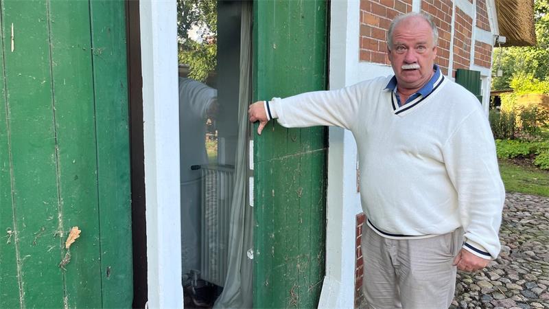 Saniertes Reetdachhaus in Hammah: Warum es eine Wundertüte ist Marcus Müller zieht eine verdeckte Schiebetür hinter der Ziegelwand hervor.