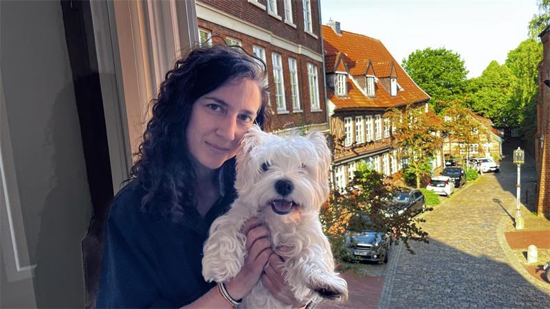 Maria Ros Marín und ihre Westie-Hündin Uma können von ihrer Wohnung aus die Sonne hinter St. Cosmae untergehen sehen - wie ihr Vorbewohner Vincent Lübeck.