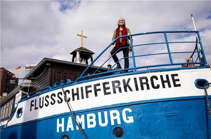 Maria Sabine Förster, ehemalige Pastorin, steht auf der Flussschifferkirche – Deutschlands einziger schwimmender Kirche . Foto: Christian Charisius/dpa