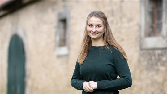 Marie von Schnehen, Landwirtin, steht vor einer Scheune.