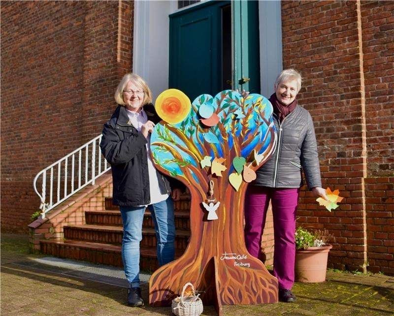 Marina Remstedt (links) und Angela Vorrath mit dem Baum der Erinnerung vor der Freiburger Kirche. Foto: Kirchengemeinde
