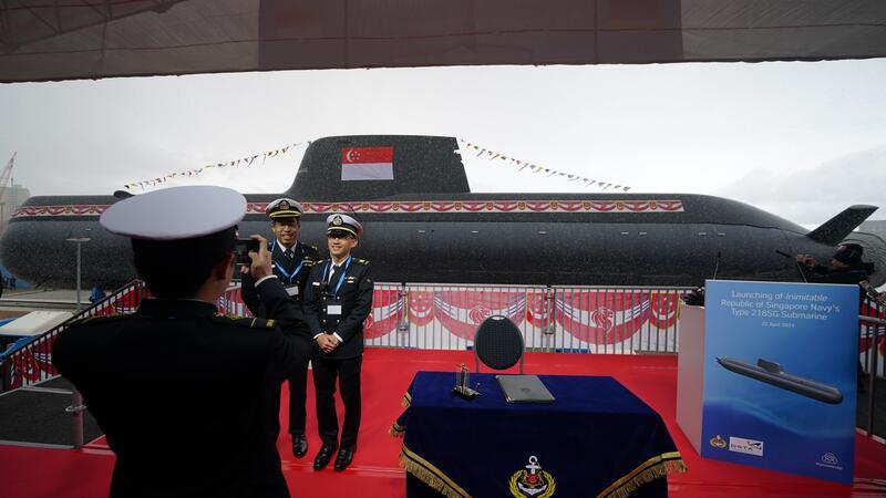 Marine-Mitglieder aus Singapur fotografieren sich vor einem U-Boot.