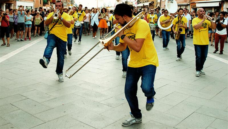 Brass Band in einer Parade, die Marinella Senatore über ihre School of Narrative Dance zusammen mit Menschen aus dem jeweiligen Ort gestaltet