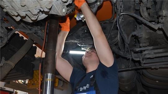 Marius Zwernemann baut in der Werkstattgrube über Kopf die Magnetkupplung wieder ein.