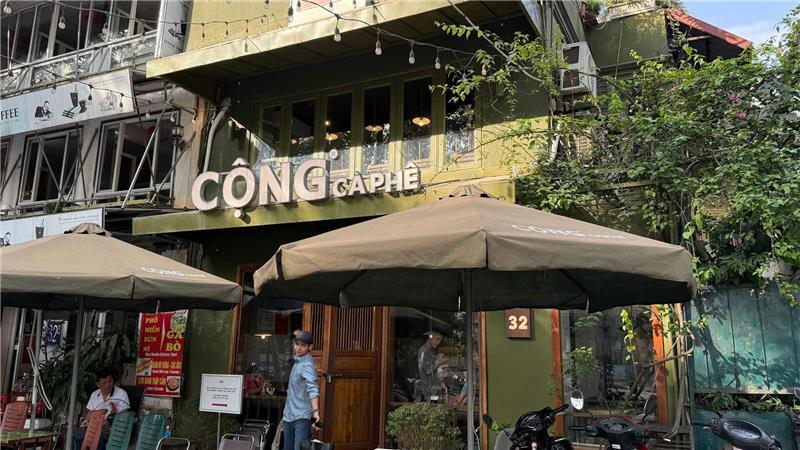 Kellner in Militärkluft: Vietnams kultigste Kaffeehauskette Markenzeichen ist ein khaki-grüner Außenanstrich.