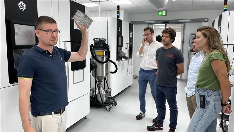 Markus Glauche (links) und Isabel Flesch Laforce (rechts) führen Kollegen einer britischen Tochterfirma von Implantcast durch den 3D-Druck.