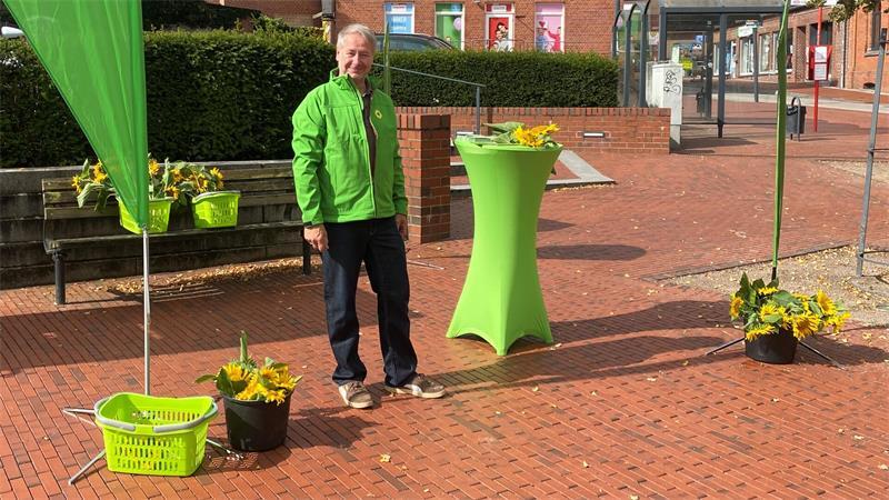 Mit Bürgern im Gespräch: Harsefelder Grüne verteilen Sonnenblumen Markus Wilshusen von den Harsefelder Grünen am Infostand in der Marktstraße in Harsefeld.