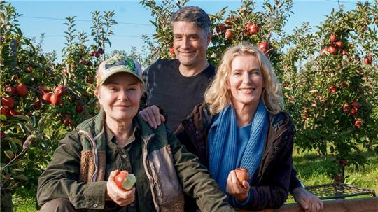 Marlies Feldhusen (Lina Wendel, von links), Regisseur Johannes Naber und Charlotte Lindholm (Maria Furtwängler) stehen bei Drehstart von „Tatort: Königin“ im Alten Land.