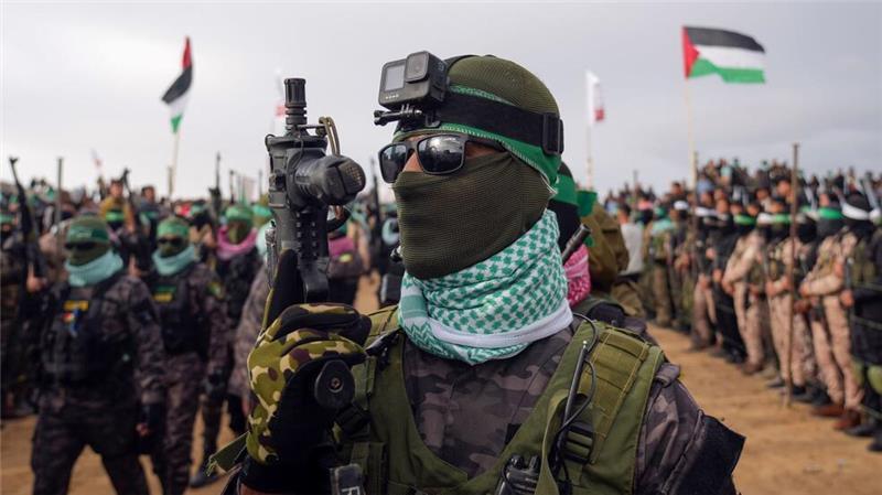 Martialischer Auftritt: Vermummte und bewaffnete Kämpfer der Terrororganisation Hamas gehen in Stellung, bevor sie die Leichen von vier israelischen Geiseln, darunter eine Mutter und ihre beiden Kinder, die seit langem für tot gehalten wurden, dem Roten Kreuz in Chan Junis im südlichen Gazastreifen übergeben wollen.
