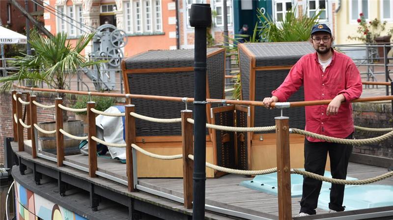 Künstler Martin Karl Kufieta steht oben an Deck des bunt bemalten Kunstkudders an der Reling