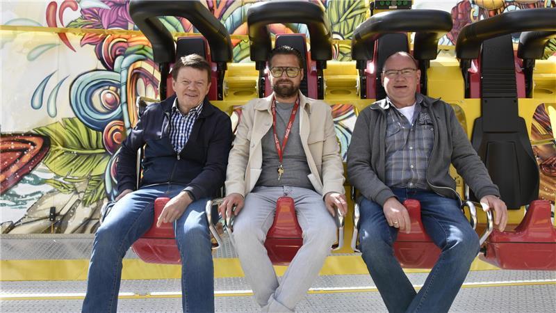 Martin Ruehs (links) und Ralf Meyer vom Heimatverein Neukloster (rechts) testen mit Robert Paulsen die Riesenschaukel.