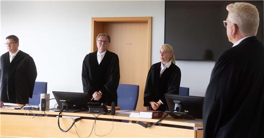 Martin Saal (2.v.l), Vorsitzender Richter, und Richard Uhle (r), Rechtsanwalt, stehen im Verhandlungssaal des Oberlandesgerichts Hamm. Foto: Dieter Menne/dpa